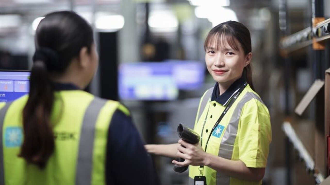 Woman smiling in warehouse in Malaysia.
