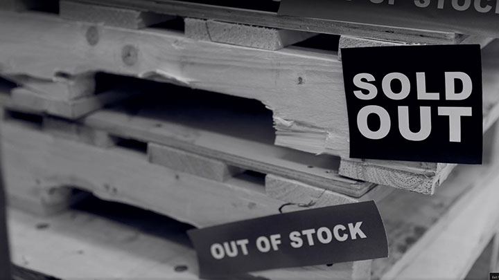 Empty shelves with sold out and out of stock signs.