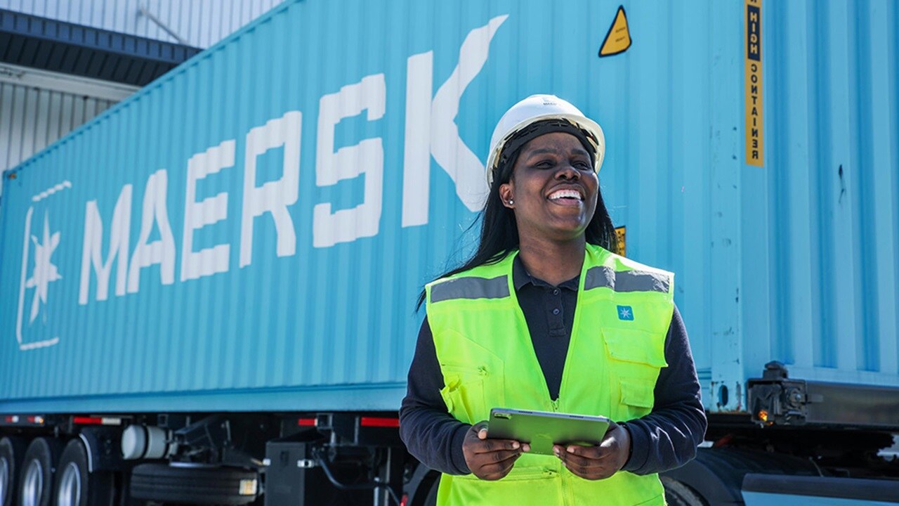 Employee standing in front of blue container