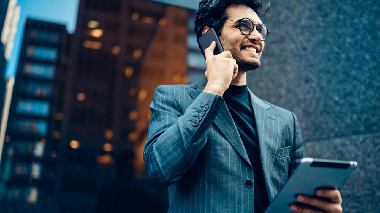 A smiling man in a suit represents the benefits of AI in logistics and supply chains.