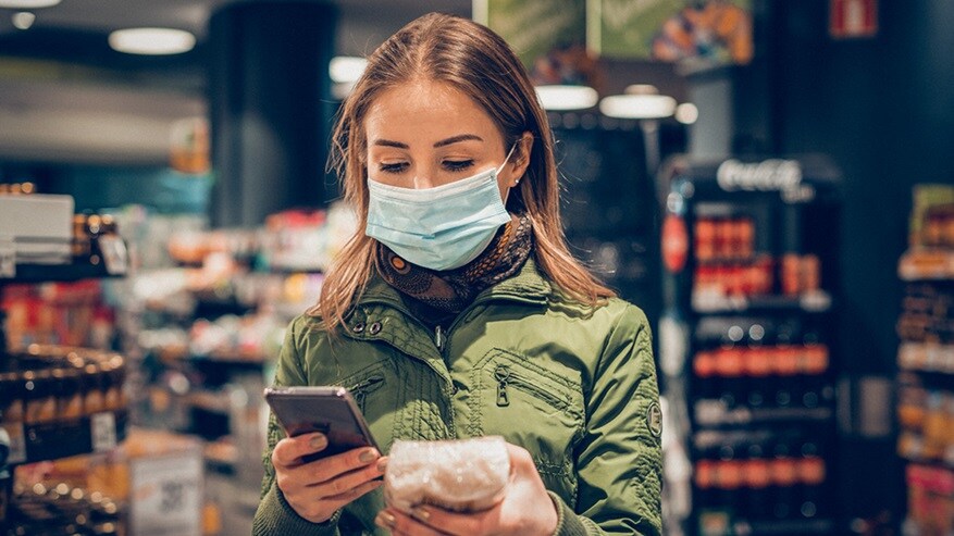Woman with mask and phone at a market