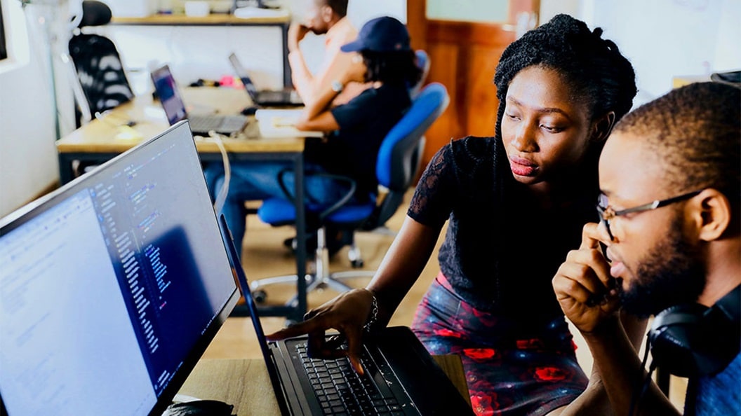 Man and woman sitting in front of a monitor.