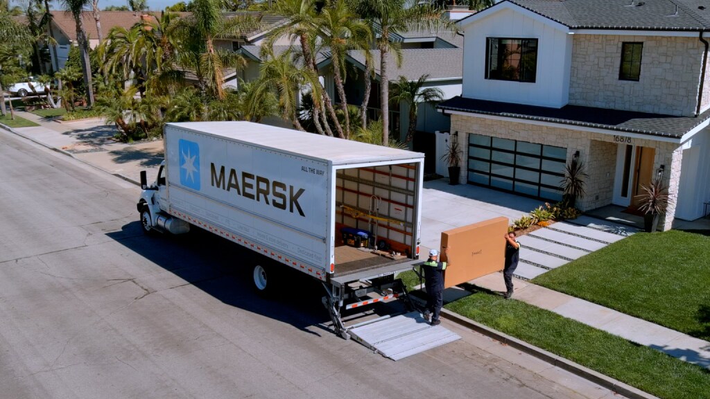 Maersk home delivery truck transporting and unloading a large package