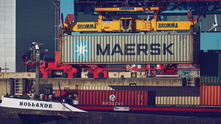 Stacked shipping containers being loaded or unloaded at a port