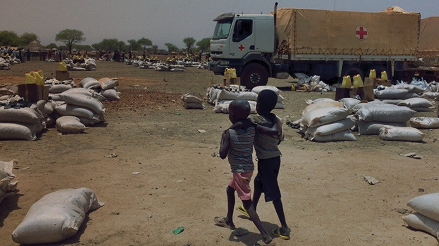 Africa – A truck carrying cargo is arriving at the unloading point with people standing at the site.