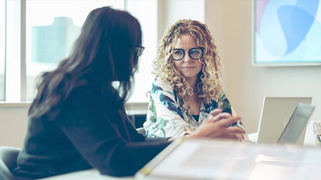 Two female conversing in an office
