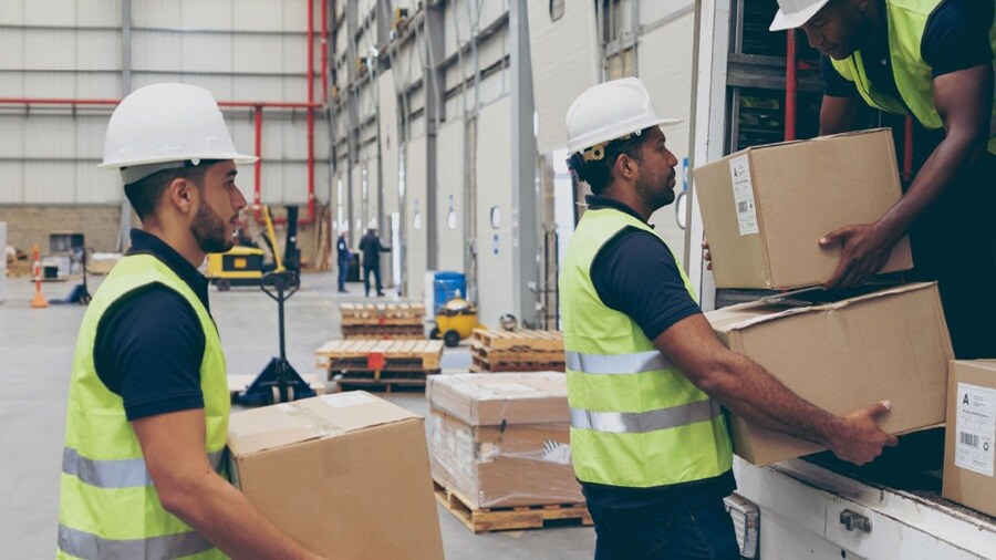 Workers unloading boxes from a container