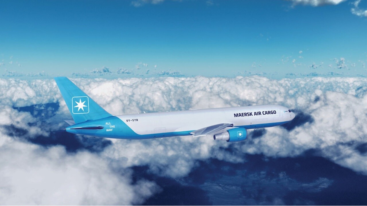 A blue and white Maersk airplane soaring through a clear blue sky, showcasing its sleek design and vibrant colors.