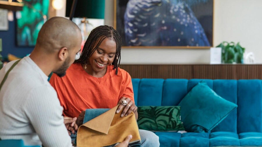 A couple sits comfortably on a couch in a well-decorated living room.