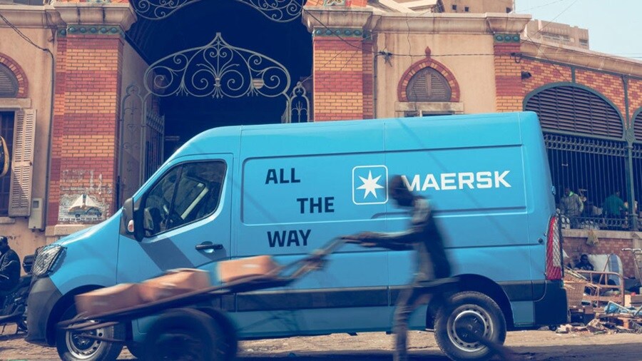 A blue van parked in front of a building, showcasing its vibrant color against the urban backdrop.