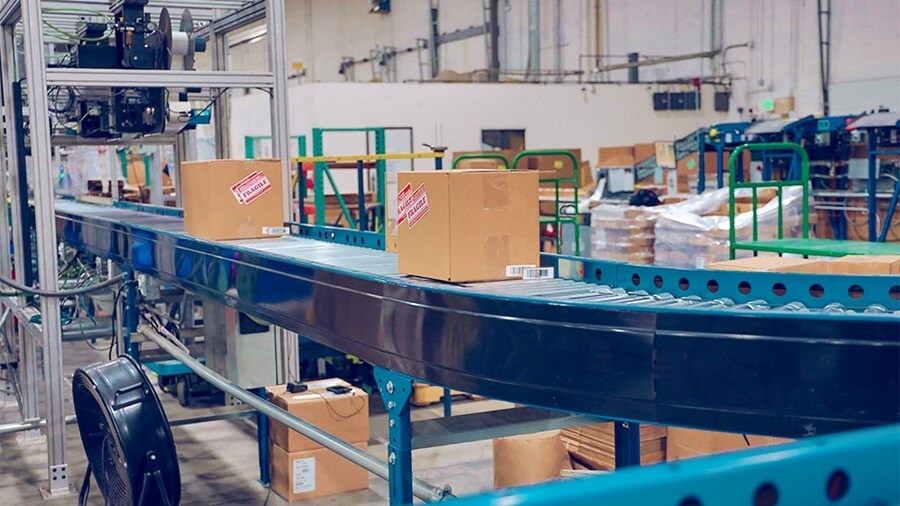 Two parcels marked fragile on a conveyor belt in a warehouse.