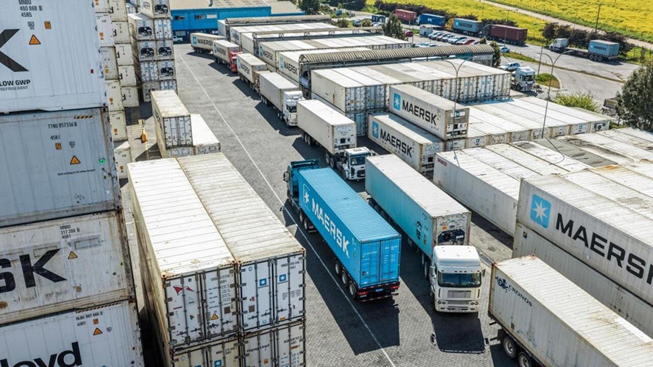 Maersk containers loaded on a freight rail and truck for intermodal transport at terminal