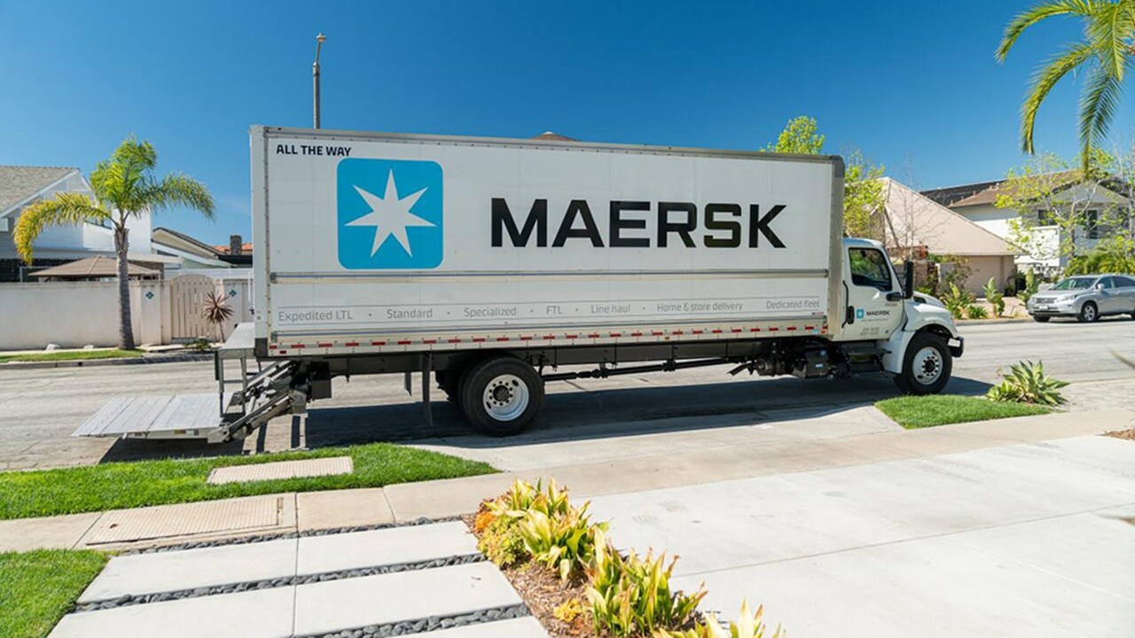 A Maersk ground freight truck parked outside a residential home for last-mile delivery.
