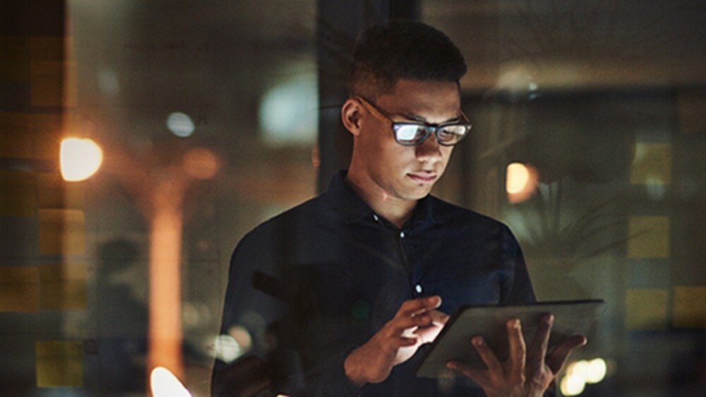 A young man using their tablet to explore API solutions.