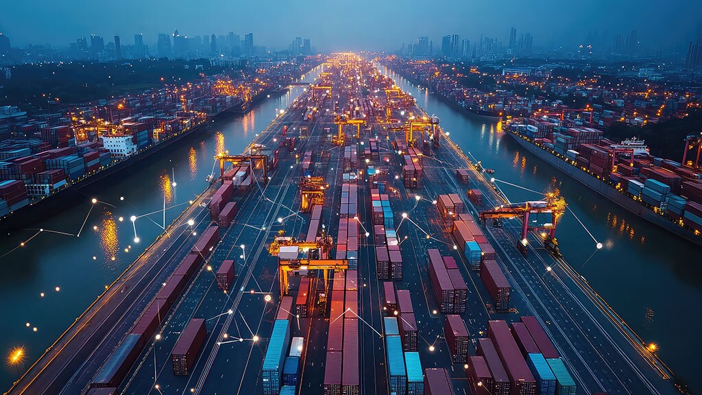 Aerial night view of a busy container port with cranes, cargo containers, and illuminated logistics network connections across the terminal.