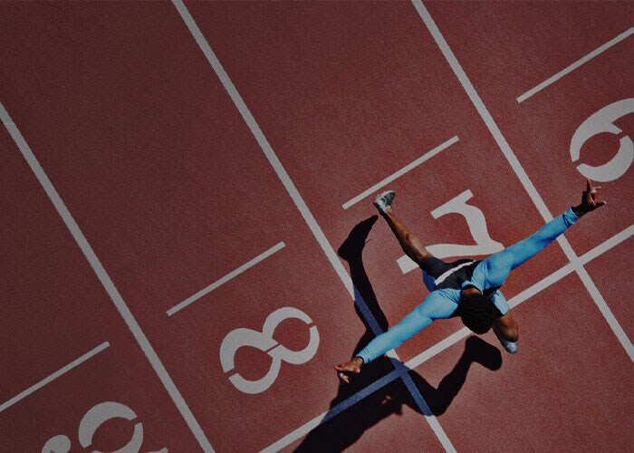 Sports & outdoor logistics - An athlete at the finish line on a racetrack, winning a sporting event.