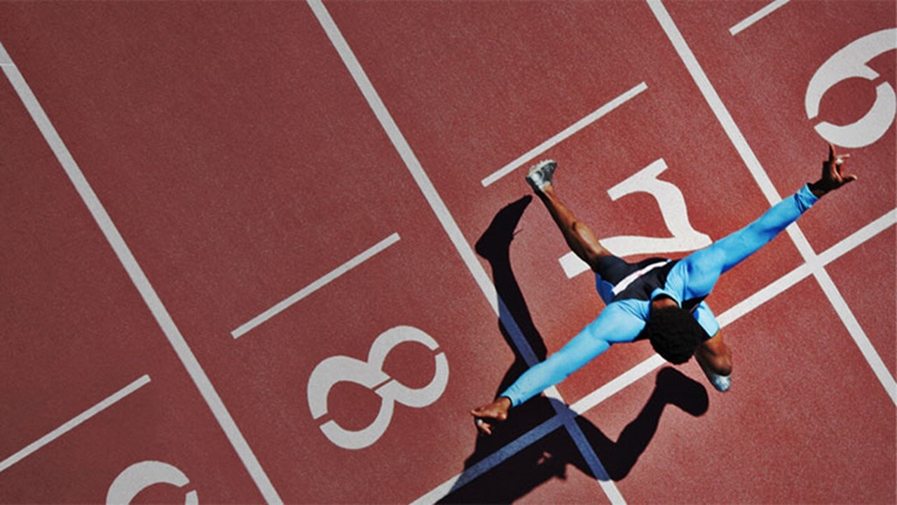 Sports & outdoor logistics - An athlete at the finish line on a racetrack, winning a sporting event.