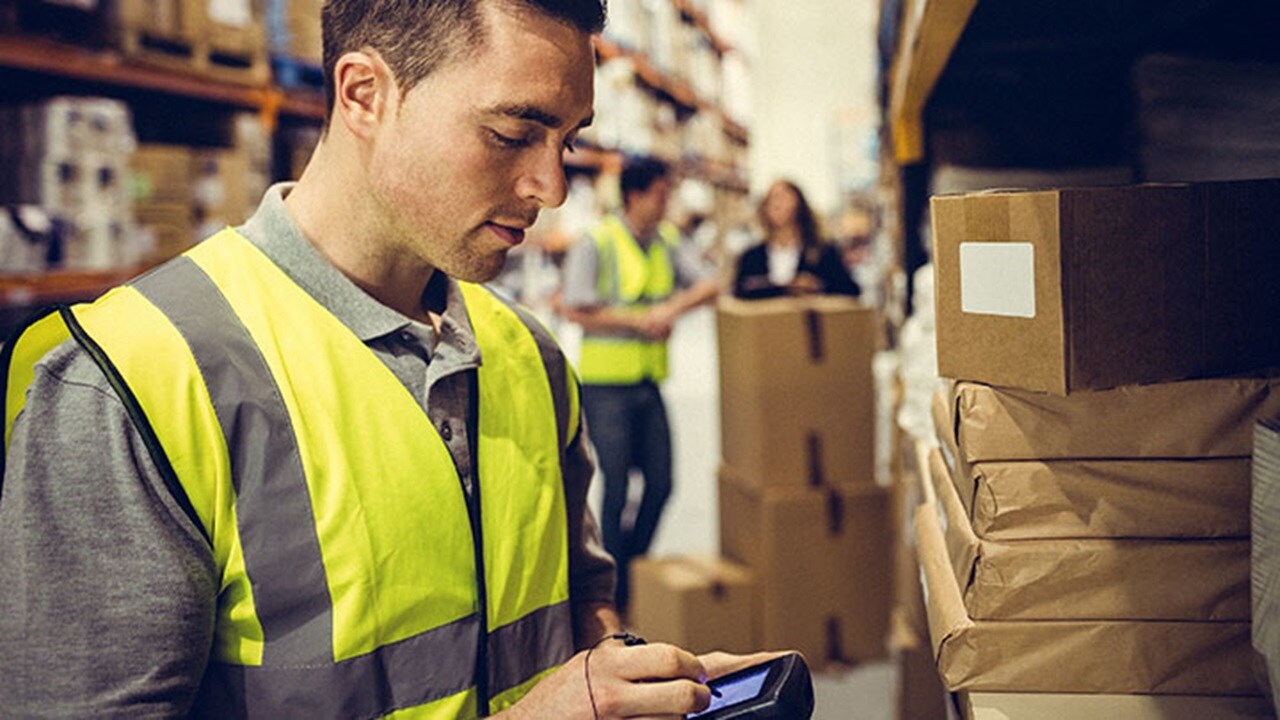 Man holding electronic scanner in warehouse