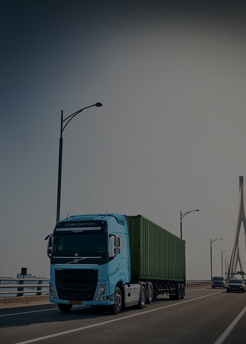 Luftaufnahme eines großen intermodalen Container-Yards mit gestapelten Versandcontainern verschiedener Farben und Marken.