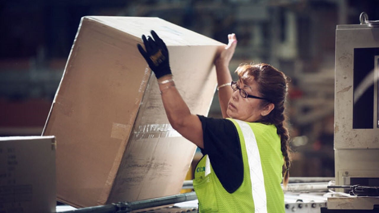 A woman worker handling a LCL cargo in a warehouse.