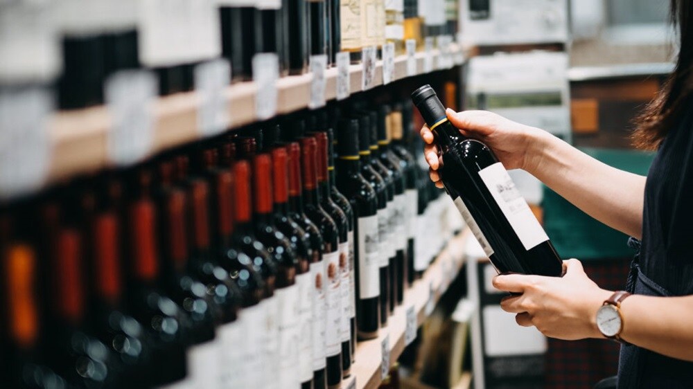 A set of hands holding a bottle of wine